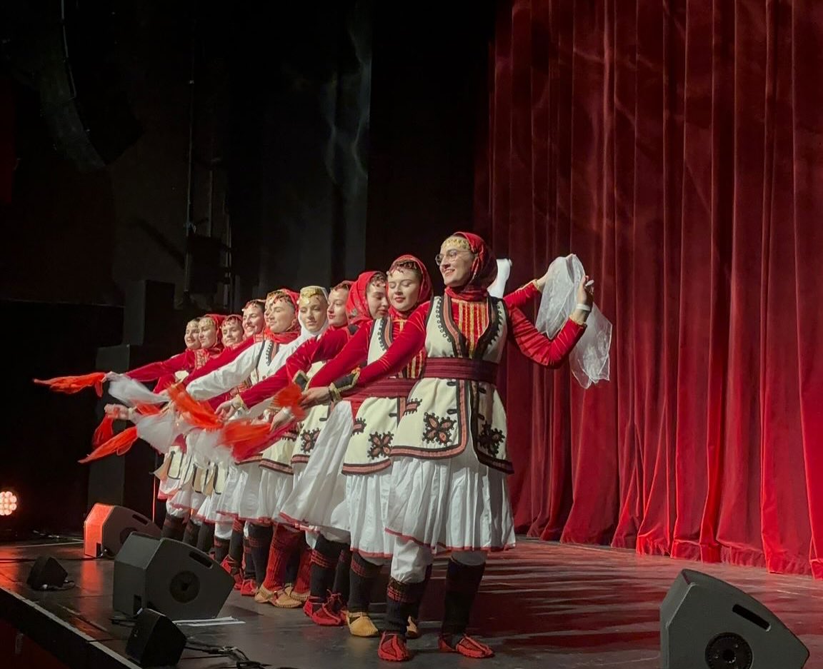 Tänzerinnen auf der Bühne vor rotem Vorhang